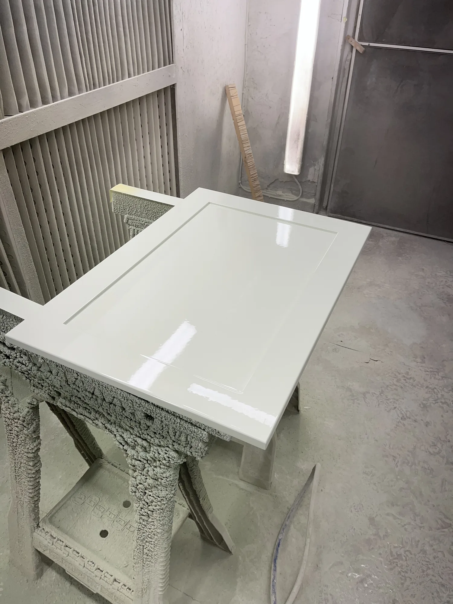 Sprayed white kitchen fronts curing on the workshop bench