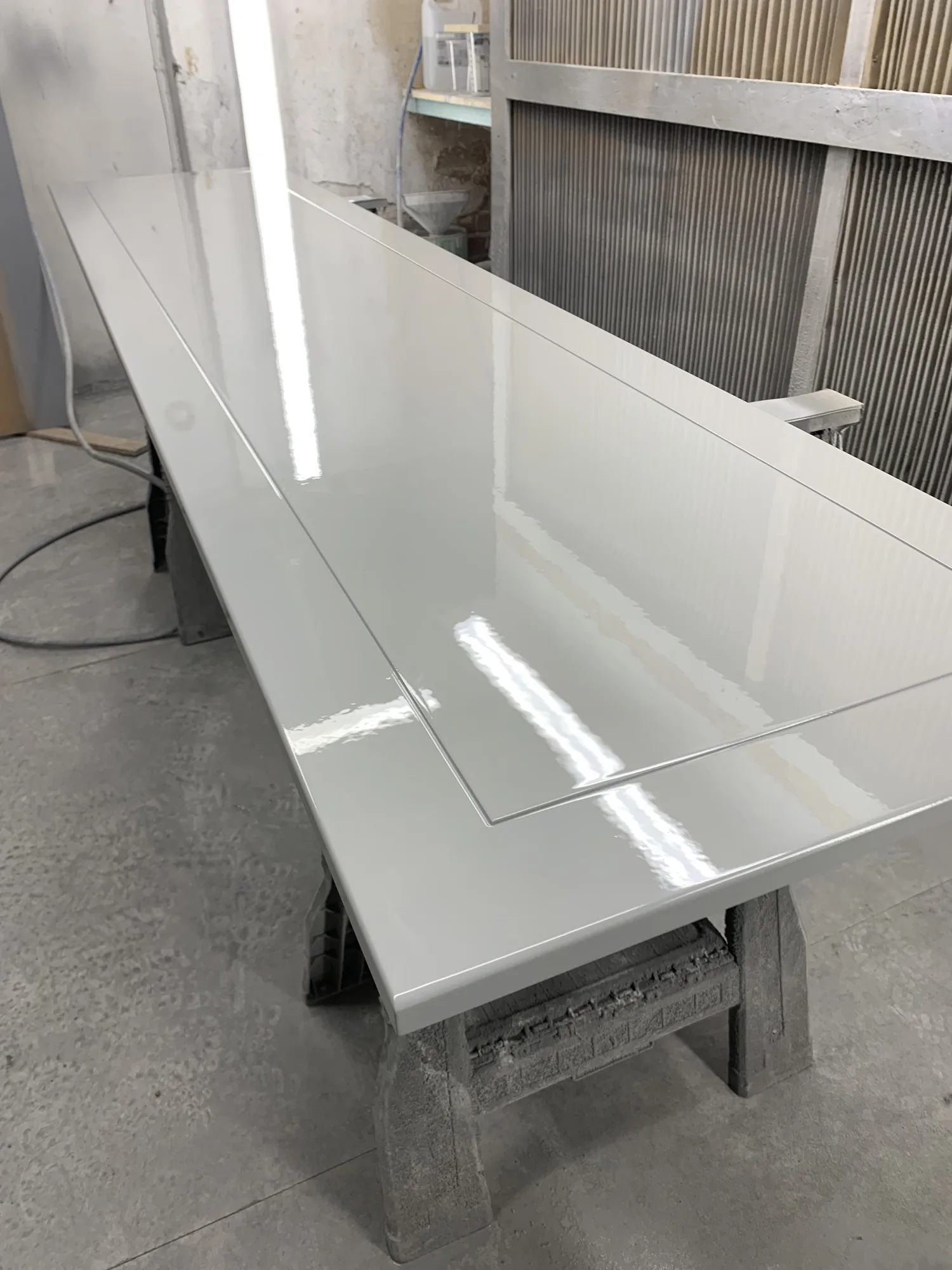 Spray-finished cabinet parts drying on trestles in the workshop